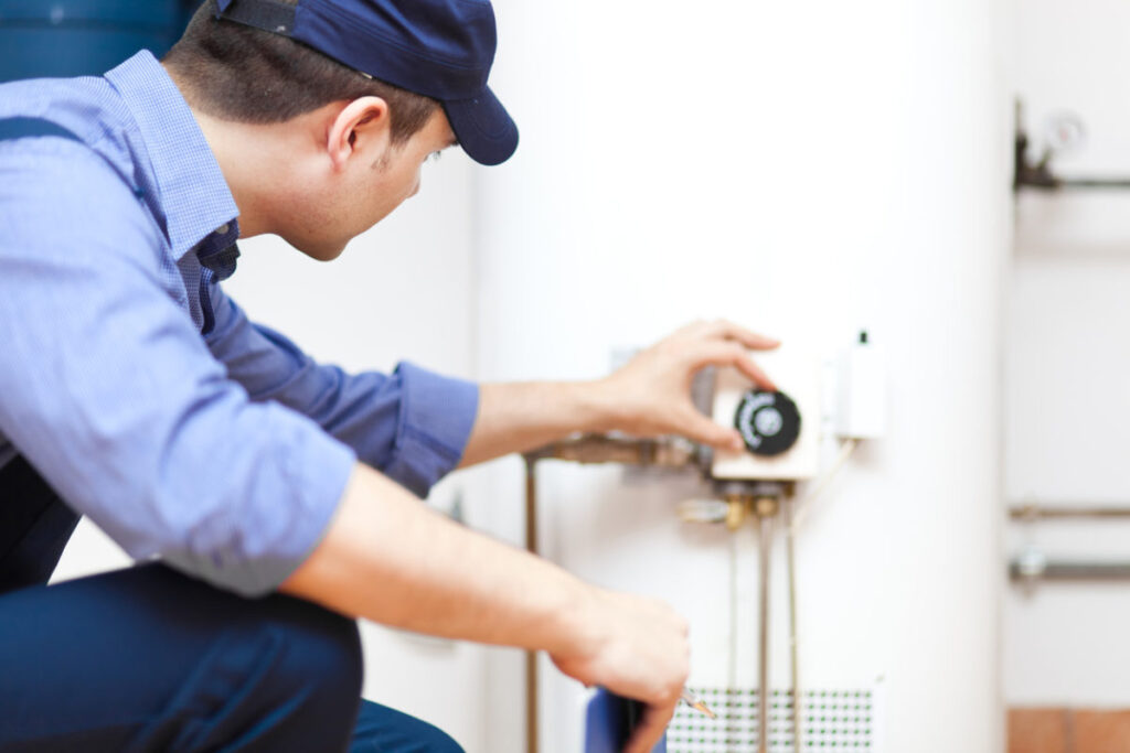 plumber repairing the water heater in someone's home