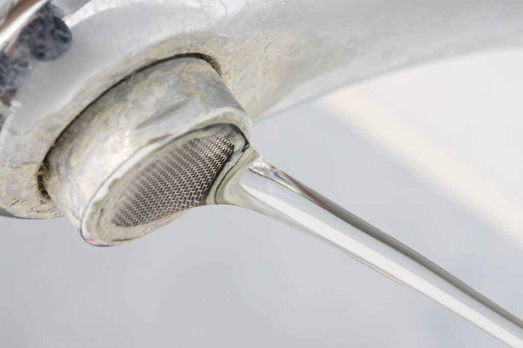 Hard water buildup on sink faucet with water running