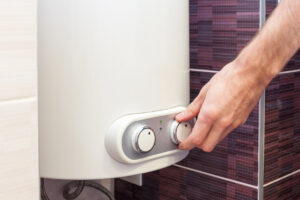 Close-up of man hands setting the temperature of water in water heater.